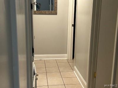 hall featuring tile patterned floors and baseboards