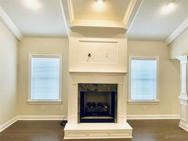 unfurnished living room featuring dark wood-type flooring, baseboards, ornamental molding, and a fireplace with raised hearth