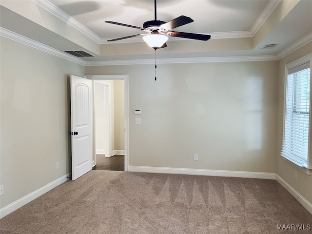 empty room featuring visible vents, a raised ceiling, and carpet floors