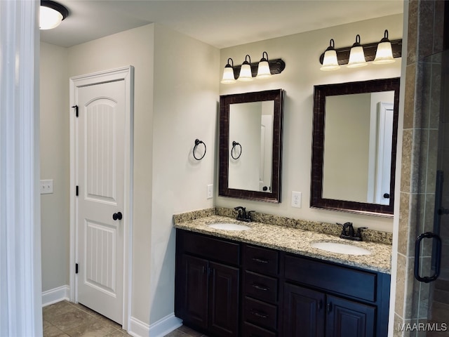 bathroom featuring baseboards, tile patterned floors, double vanity, and a sink