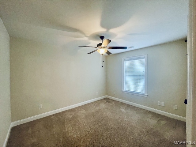 empty room with baseboards, visible vents, ceiling fan, and carpet floors