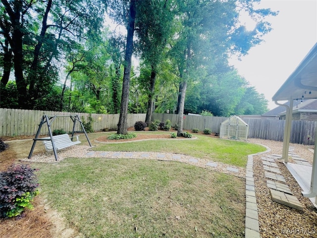 view of yard featuring an outdoor structure, an exterior structure, and a fenced backyard