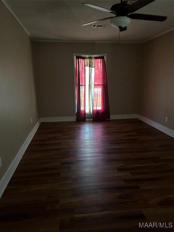 222 Woodbine St, Selma, AL 36701 - empty room featuring dark wood-style floors, a ceiling fan, baseboards, and crown molding