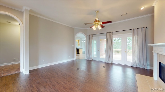 unfurnished living room featuring french doors, a ceiling fan, visible vents, arched walkways, and hardwood / wood-style floors