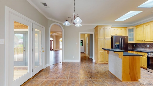 kitchen featuring dark countertops, appliances with stainless steel finishes, an inviting chandelier, a breakfast bar area, and visible vents