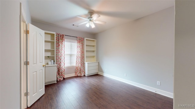 unfurnished bedroom featuring baseboards, dark wood finished floors, ceiling fan, and visible vents