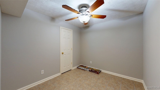 spare room with baseboards, ceiling fan, and a textured ceiling