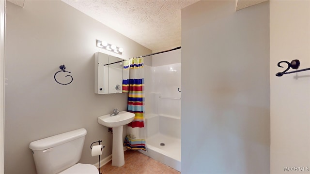 full bath featuring a textured ceiling, tile patterned floors, toilet, and a shower with curtain