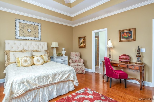 bedroom with baseboards, ornamental molding, and wood finished floors