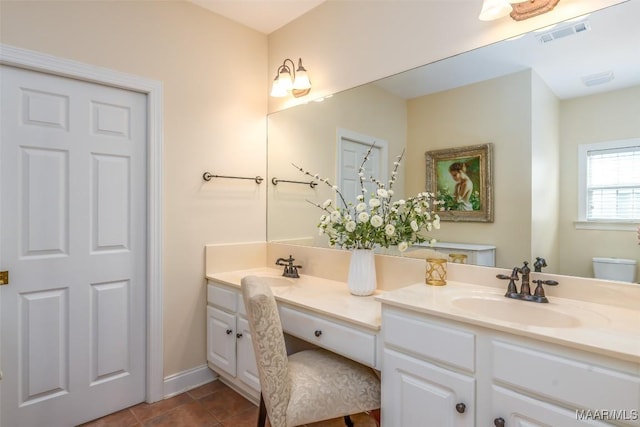 full bath with visible vents, double vanity, toilet, tile patterned floors, and a sink