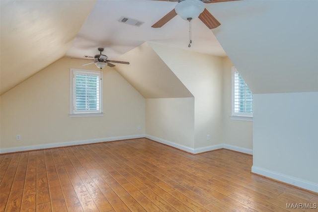 bonus room featuring a ceiling fan, visible vents, plenty of natural light, and light wood-style floors