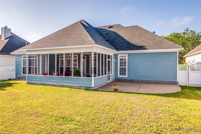 back of house featuring fence, a patio, roof with shingles, a sunroom, and a lawn