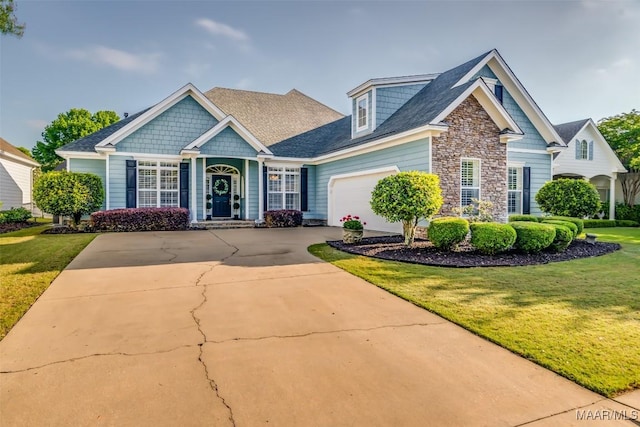 craftsman house featuring a garage, a front yard, driveway, and stone siding