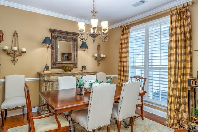 dining area with visible vents, wood finished floors, a chandelier, and a wealth of natural light