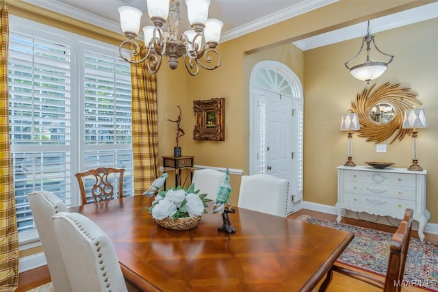 dining room with baseboards, an inviting chandelier, ornamental molding, and wood finished floors