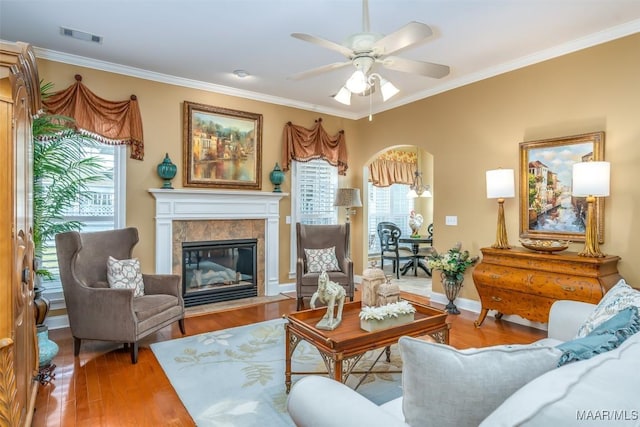 living room featuring plenty of natural light, ornamental molding, and visible vents
