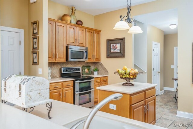 kitchen featuring baseboards, light countertops, tasteful backsplash, hanging light fixtures, and stainless steel appliances