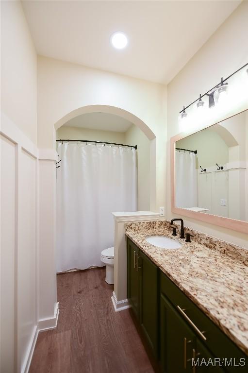 bathroom with recessed lighting, vanity, toilet, and wood finished floors