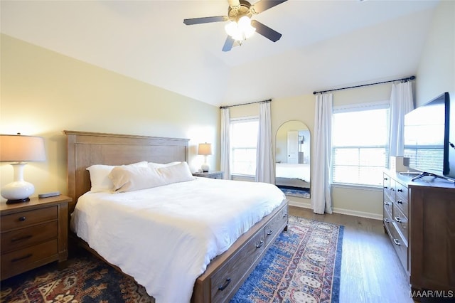 bedroom with ceiling fan, multiple windows, lofted ceiling, and dark wood-type flooring