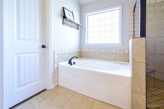 bathroom with tile patterned flooring and a garden tub