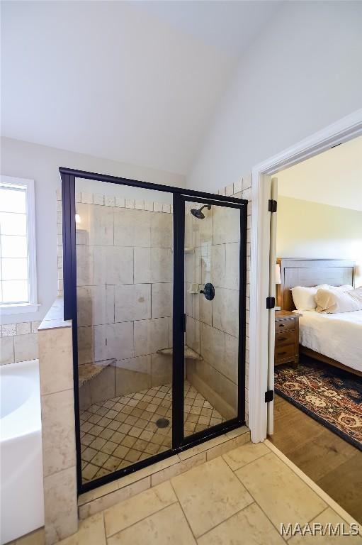 ensuite bathroom with ensuite bathroom, a garden tub, a stall shower, and vaulted ceiling