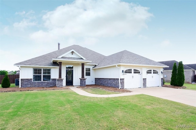 view of front of home with an attached garage, driveway, a front lawn, and stone siding