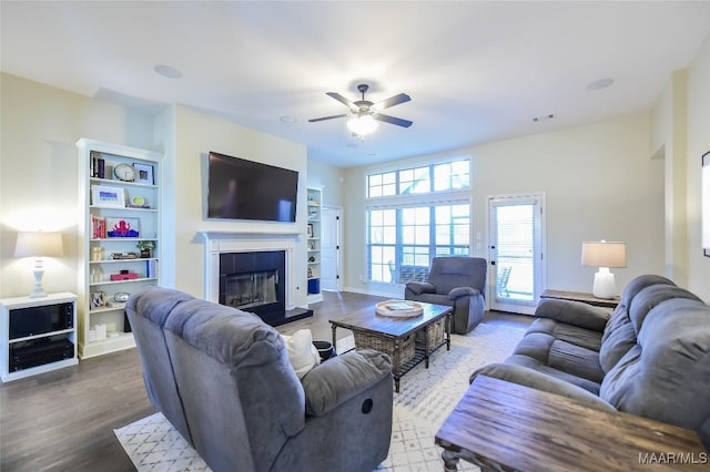 living room featuring visible vents, ceiling fan, a tile fireplace, and wood finished floors