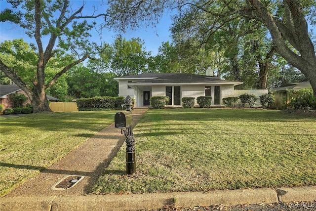 view of front of property with a chimney, fence, and a front yard