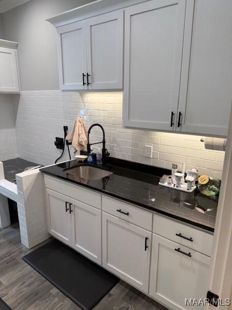 169 Foxfire Ct, Wetumpka, AL 36092 - kitchen with backsplash, white cabinetry, a sink, and dark wood-type flooring