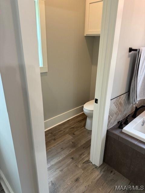169 Foxfire Ct, Wetumpka, AL 36092 - bathroom featuring baseboards, a garden tub, wood finished floors, and toilet