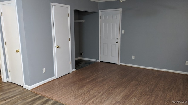 unfurnished bedroom featuring baseboards, ornamental molding, and wood finished floors