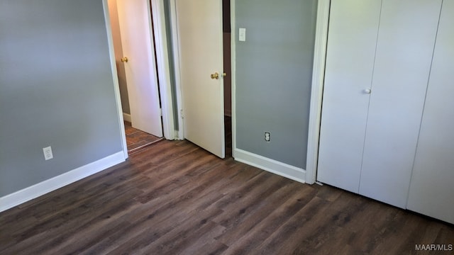 unfurnished bedroom with baseboards and dark wood-style flooring