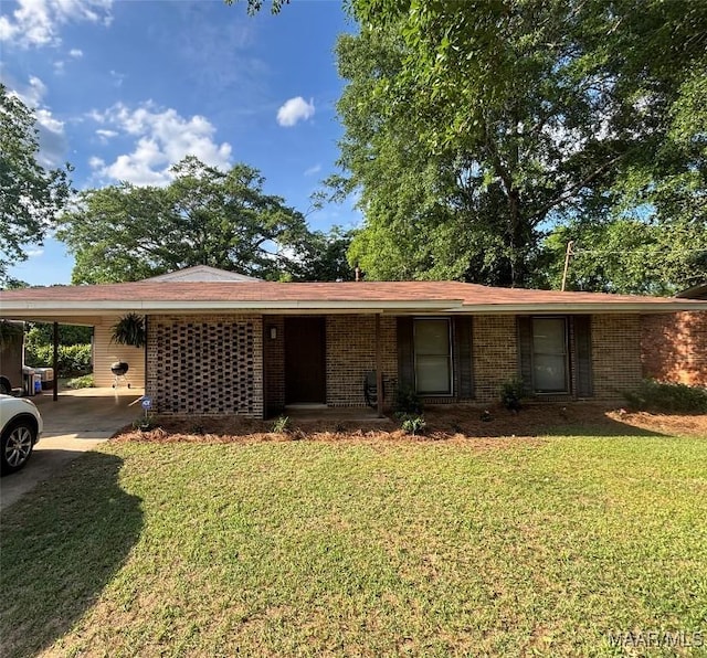 single story home featuring brick siding, driveway, a front yard, and a carport