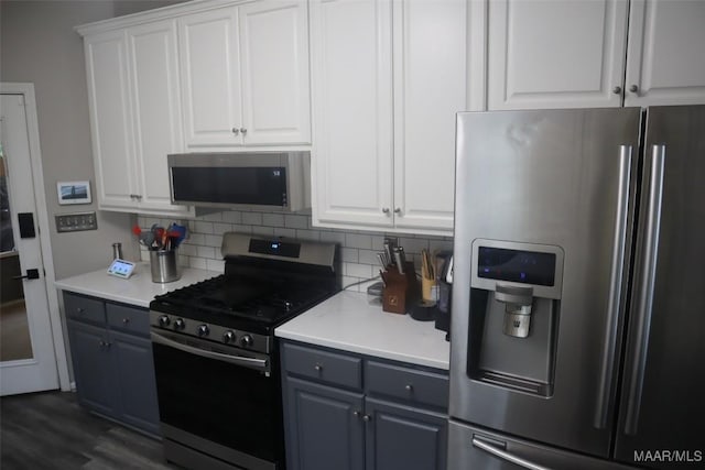 kitchen with white cabinets, light countertops, gray cabinets, stainless steel appliances, and tasteful backsplash