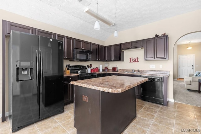kitchen featuring dark brown cabinetry, pendant lighting, arched walkways, a center island, and black appliances