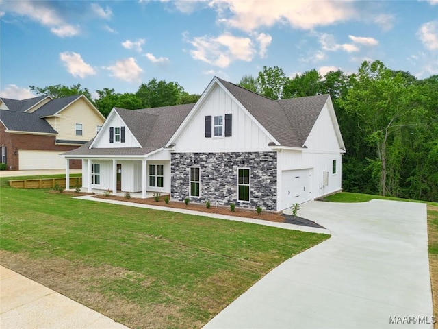 view of front of home featuring roof with shingles, a front lawn, stone siding, board and batten siding, and concrete driveway