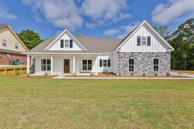 modern inspired farmhouse featuring stone siding, a front yard, a shingled roof, board and batten siding, and a porch