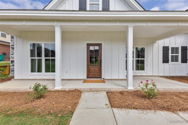 doorway to property with board and batten siding and a porch