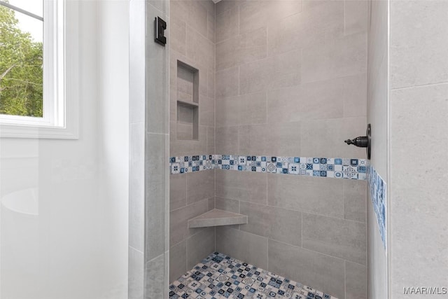 full bathroom featuring plenty of natural light and a tile shower