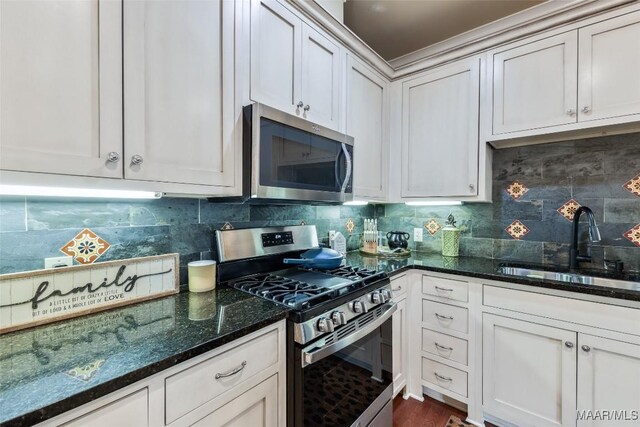 105 Bell Pkwy, Wetumpka, AL 36092 - kitchen featuring white cabinets, appliances with stainless steel finishes, a sink, dark stone counters, and backsplash