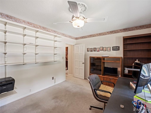 office space featuring carpet floors, ceiling fan, and baseboards