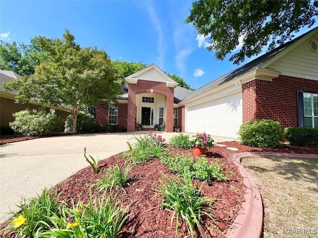 view of front of home with brick siding, an attached garage, and concrete driveway