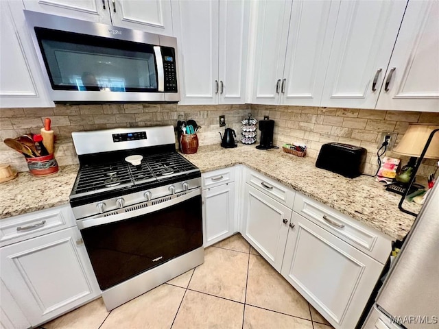 kitchen with appliances with stainless steel finishes, decorative backsplash, and white cabinetry