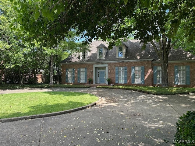 view of front of house featuring brick siding and a front lawn
