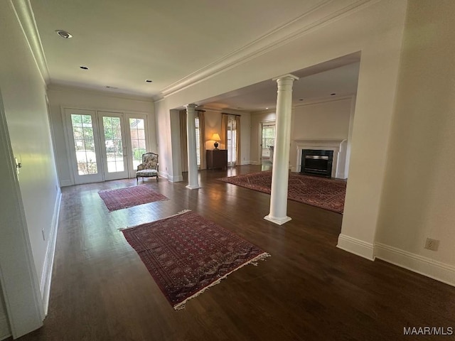 living area with baseboards, ornamental molding, decorative columns, and wood finished floors