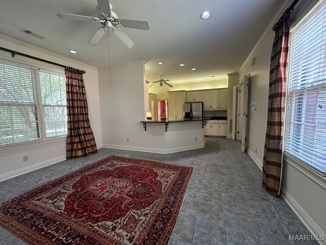 living area with visible vents, a ceiling fan, baseboards, and ornamental molding
