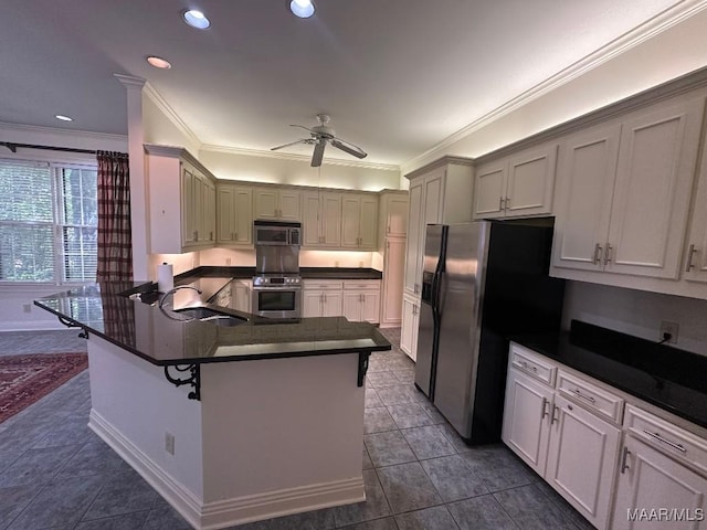kitchen with ceiling fan, dark countertops, appliances with stainless steel finishes, a sink, and ornamental molding