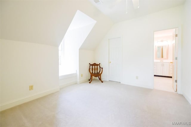 additional living space featuring ceiling fan, lofted ceiling, visible vents, and light colored carpet
