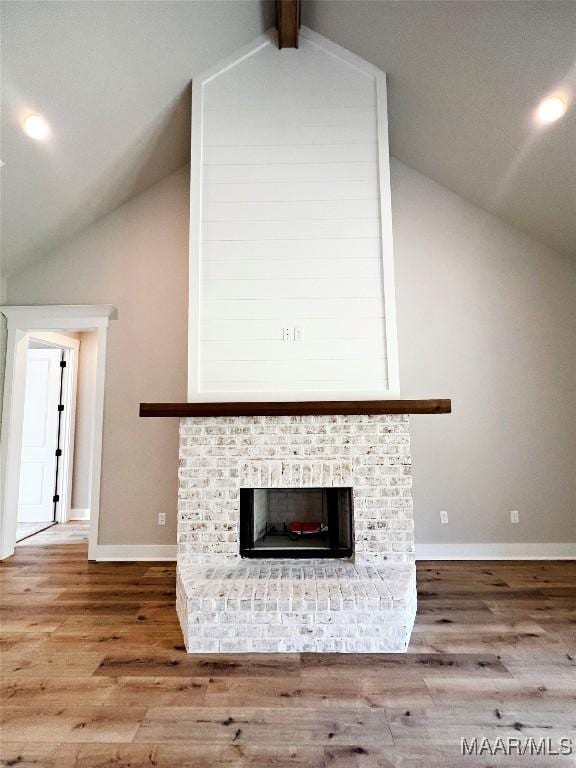 171 Mountain Laurel Rdg, Wetumpka, AL 36093 - unfurnished living room with lofted ceiling, wood finished floors, baseboards, and a brick fireplace
