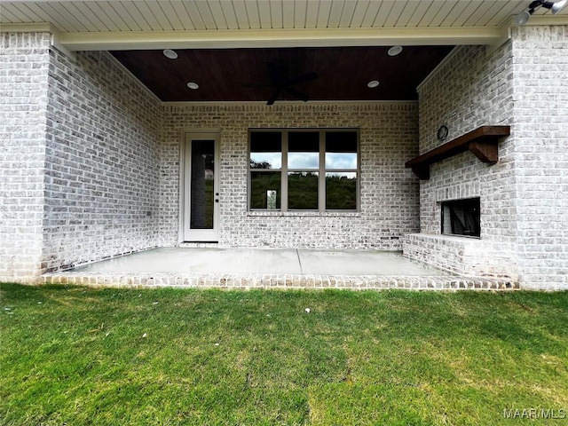 171 Mountain Laurel Rdg, Wetumpka, AL 36093 - doorway to property featuring a ceiling fan, brick siding, a patio area, and a yard